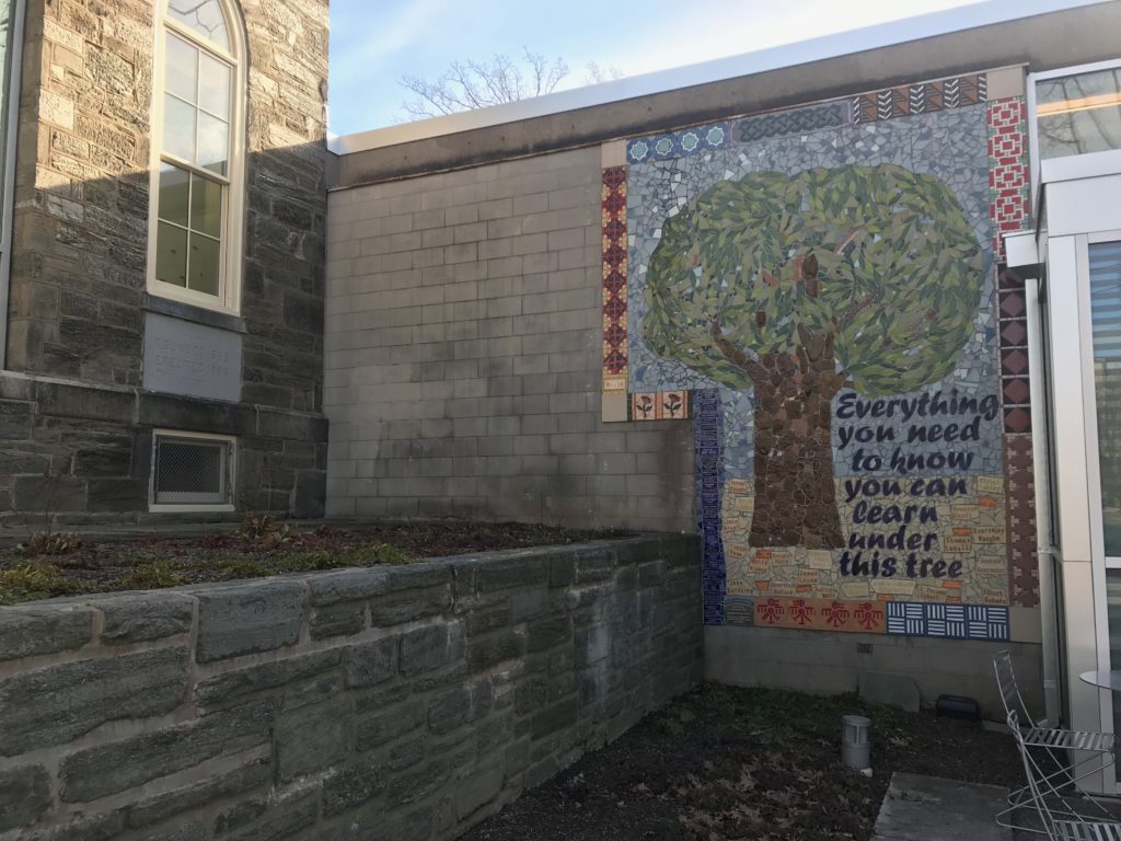 Mosaic on library with image of tree and the phrase "Everything you need to know you can learn under this tree"