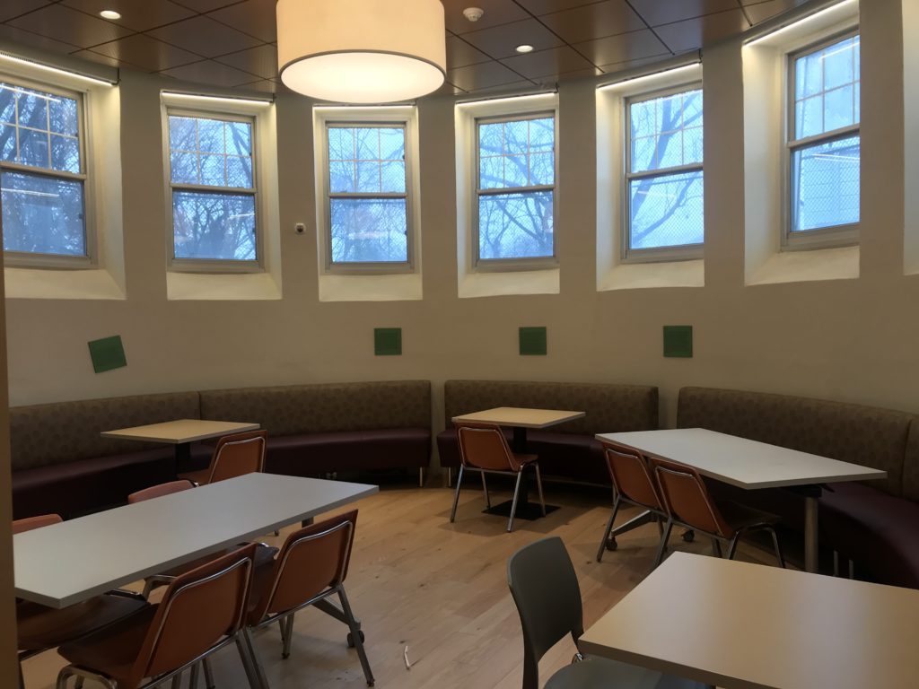 Tables and chairs around a large, round room with windows