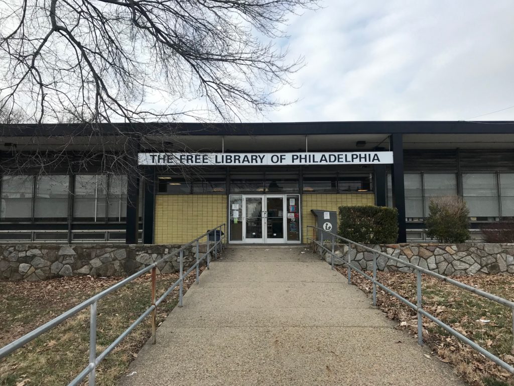 Sidewalk leading up to building with "The Free Library of Philadelphia" sign